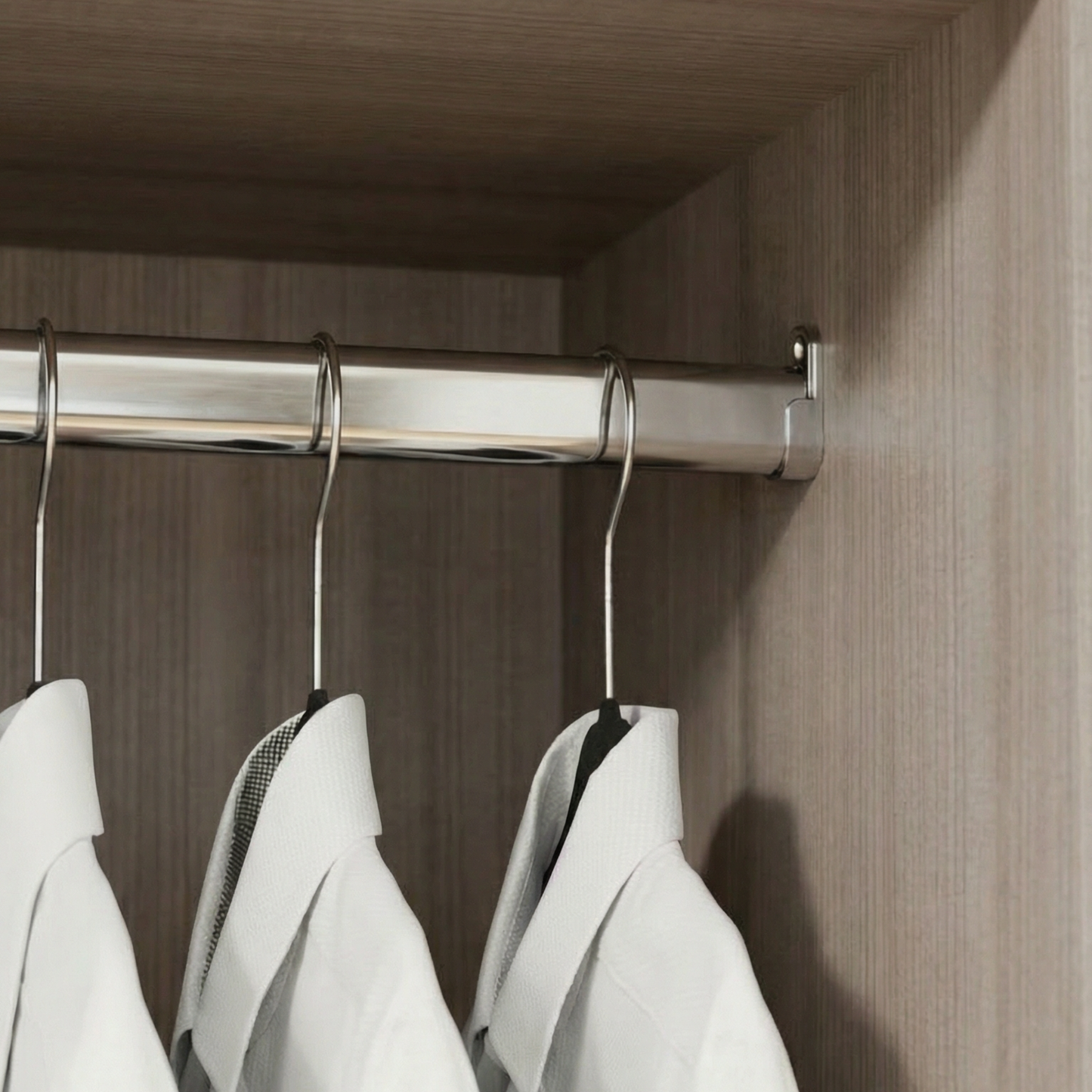 clóset metálico con camisas blancas colgadas